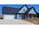 Charming single-story home with blue horizontal siding, stone accents, and attached two-car garage at 32531 Buchanan Ln, Albemarle, NC 28001
