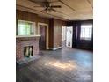 Spacious living room with a brick fireplace, wood floors, and multiple doorways at 40 Ranlo Ave, Gastonia, NC 28054