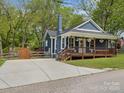 Side view of a cozy blue home featuring a front porch and concrete driveway at 402 Sidney Johnson St, Fort Mill, SC 29715