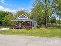 Quaint blue home with inviting front porch, American flag, and lush green lawn at 402 Sidney Johnson St, Fort Mill, SC 29715