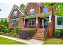 A welcoming brick-lined porch with red chairs, offering a relaxing outdoor space with manicured landscaping at 4711 Pearmain Dr, Waxhaw, NC 28173