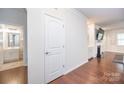 Bright hallway leading to a bathroom, living room with fireplace, and beautiful hardwood flooring at 529 Cellini Pl # 243, Mount Holly, NC 28120