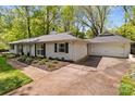 Side view of a well-maintained white brick house featuring a two-car garage and landscaped yard at 641 Charter Pl, Charlotte, NC 28211