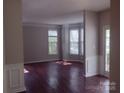 Sunlit living room with hardwood floors, large windows, and neutral paint, creating a welcoming ambiance at 7731 Harrington Woods Rd # 17, Charlotte, NC 28269