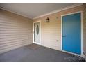 Covered front porch with decorative sconce and blue door at 8412 Cricket Lake Dr, Charlotte, NC 28277