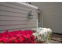 Up close exterior shot with colorful flowering shrubs and sconce at 8412 Cricket Lake Dr, Charlotte, NC 28277