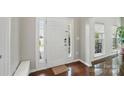 Bright foyer featuring hardwood floors, white trim, and a sidelight at 8923 Happiness Rd, Harrisburg, NC 28075