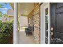 Inviting covered porch with brick columns and a cozy seating area at 8923 Happiness Rd, Harrisburg, NC 28075