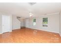 Spacious living room with hardwood floors, a ceiling fan, and plenty of natural light from multiple windows at 9419 Isaac Hunter Dr, Charlotte, NC 28214