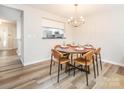Dining room featuring hardwood floors, modern chandelier and seating for six at 1203 Maple Shade Ln, Charlotte, NC 28270