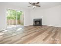 Bright living room features hardwood floors, ceiling fan and fireplace with access to a private deck at 1203 Maple Shade Ln, Charlotte, NC 28270