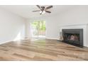 Bright living room features hardwood floors, a ceiling fan and fireplace with access to a private deck at 1203 Maple Shade Ln, Charlotte, NC 28270