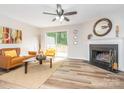 Cozy living room with a fireplace, stylish decor, and sliding door access to the deck at 1203 Maple Shade Ln, Charlotte, NC 28270