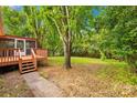 Backyard with a wooden deck, patio, and tree shaded lawn at 1204 Meadowood Dr, Shelby, NC 28150