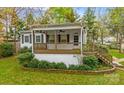 Home with covered porch, a well-maintained lawn, and garden area at 132 Larboard Trl, Mount Gilead, NC 27306