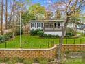 Home with a well-maintained lawn, a quaint fence, and retaining walls at 132 Larboard Trl, Mount Gilead, NC 27306