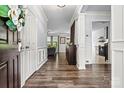 Inviting entryway with hardwood floors and traditional wainscoting detailing leading into the kitchen and living room at 158 Bluffton Rd, Mooresville, NC 28115