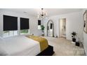 Bright bedroom with windows, carpet, modern light fixture, and a large, decorative mirror at 1911 Almond Hills Dr, Charlotte, NC 28262