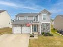 Beautiful two-story home with a two-car garage and landscaped front yard on a sunny day at 228 Brownstone Dr, Rock Hill, SC 29730