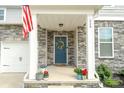 Inviting front porch with a blue door, decorative wreath, and charming stone accents at 228 Brownstone Dr, Rock Hill, SC 29730