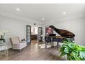 Elegant living room features hardwood floors, a baby grand piano, and refined details at 2500 Giverny Dr, Charlotte, NC 28226