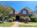 Beautiful two-story brick condo featuring well-maintained landscaping and a 'For Sale' sign in the front yard at 2527 Carya Pond Ln, Charlotte, NC 28212