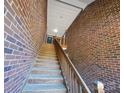 A wood staircase leads to a townhome's entrance, flanked by textured brick walls on each side at 2527 Carya Pond Ln, Charlotte, NC 28212