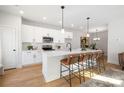 Bright open-concept kitchen features a quartz island with bar seating, new stainless appliances, and modern finishes at 4819 Victoria Ave, Charlotte, NC 28269