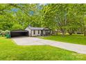 Lovely single-story home with a lush front yard, mature trees, and detached two car garage offering ample parking at 509 Carole Ln, Charlotte, NC 28214