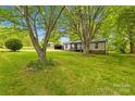 Quaint single-story home featuring mature trees, a spacious front yard, and a detached two car garage at 509 Carole Ln, Charlotte, NC 28214
