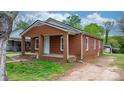 Exterior showcasing a classic brick facade, a cozy front porch, and a well-manicured lawn at 728 21St Sw St, Hickory, NC 28602