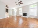 Open-concept living area with hardwood flooring, a fireplace and seamless flow to the kitchen and dining spaces at 8718 Rittenhouse Cir, Charlotte, NC 28270