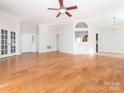 Spacious living room featuring French doors, hardwood floors, neutral paint and open to the kitchen and dining area at 8718 Rittenhouse Cir, Charlotte, NC 28270