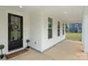 Charming porch with black front door, decorative wreath, and welcoming doormat at 8756 Sherrills Ford Rd, Sherrills Ford, NC 28673