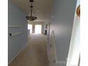 Hallway with a decorative light fixture and views to the living room and fireplace at 9668 Walkers Glen Nw Dr, Concord, NC 28027