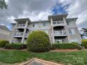 Attractive condo building showcasing multiple balconies, well-maintained lawns, and professional landscaping under a cloudy sky at 10005 Graduate Ln, Charlotte, NC 28262