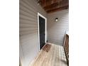 Cozy front entrance features a wooden deck with a black door with gold accents, and exterior light at 10005 Graduate Ln, Charlotte, NC 28262