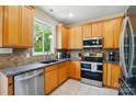 Bright kitchen with stainless steel appliances, oak cabinetry, and granite countertops at 10056 Paisley Dr, Charlotte, NC 28269
