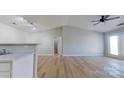 Bright living room with ceiling fan and wood-look flooring, open to kitchen, and access to an outdoor balcony at 10526 Hill Point Ct, Charlotte, NC 28262
