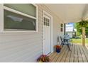 This porch features matching chairs, potted plants, a wooden deck, and a door at 109 W Poplar St, Stanley, NC 28164