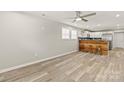 Open-concept living space with hardwood floors, sleek ceiling fan, and natural light, seamlessly connecting to the kitchen at 109 W Poplar St, Stanley, NC 28164