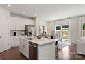 Modern kitchen with a central island, stainless steel appliances, sleek white cabinetry, and an adjacent dining area at 117 Vaquaro Dr, Mooresville, NC 28115