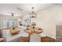 Bright dining area features a modern chandelier, adjacent to the living room with bright window doors at 1218 Green Oaks Ln # E, Charlotte, NC 28205
