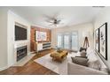 Cozy living room with a brick accent wall, fireplace, ceiling fan, and access to a patio at 1218 Green Oaks Ln # E, Charlotte, NC 28205