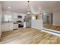 Bright, open kitchen featuring stainless steel appliances, white cabinets, and modern lighting at 1274 Oakbrook Ln, Denver, NC 28037