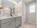 Bathroom featuring double sinks, neutral color scheme and framed artwork on the wall at 140 Shepherds Landing Dr, Mooresville, NC 28115
