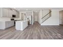 Open concept living space featuring a modern kitchen, staircase, and luxury vinyl flooring at 140 Shepherds Landing Dr, Mooresville, NC 28115