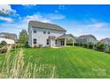 Spacious backyard features lush green lawn, covered patio, and manicured hedges, perfect for outdoor living at 1617 Post Ct, Gastonia, NC 28054