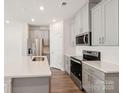 Modern kitchen with stainless steel appliances, gray cabinets, and quartz countertops at 1760 Old Rivers Rd, Concord, NC 28027