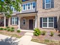 Charming brick townhome showcasing well-maintained landscaping and a welcoming front porch at 1834 Teachers House Nw Rd, Concord, NC 28027